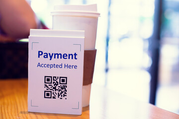 QR code payment tag with blur coffee in coffee shop or restaurant to accepted generate digital pay without money. Qr code payment concept.