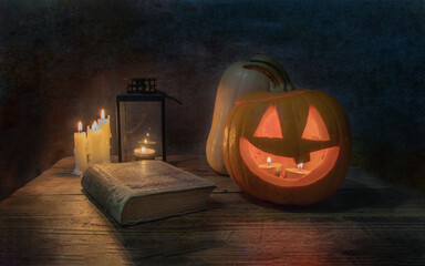 Pumpkin, candlestick, candles and old book. Halloween still life