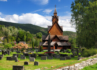 Fototapeta na wymiar View From The Cemetery To The Largest Stave Church Of Norway In Heddal On A Sunny Summer Day With A Clear Blue Sky And A Few Clouds