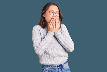 Young beautiful chinese girl wearing casual clothes laughing and embarrassed giggle covering mouth...