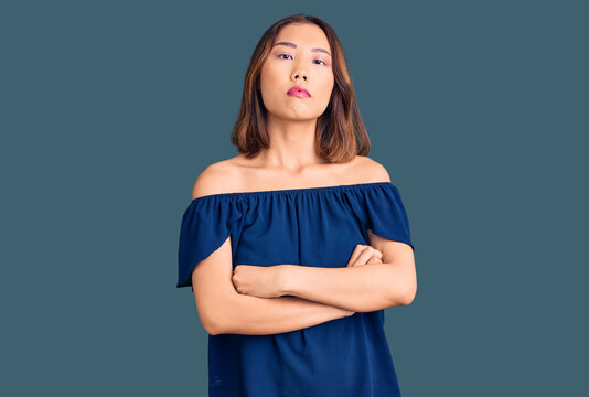 Young beautiful chinese girl wearing casual clothes relaxed with serious expression on face. simple and natural looking at the camera.