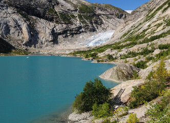 Fototapeta na wymiar View From The Lake Nigardsbrevatnet To The Glacier Nigardsbreen In Jostedalsbreen National Park On A Sunny Summer Day With A Clear Blue Sky