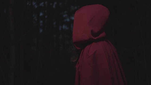 Red riding hood walking in dark woods, slow motion