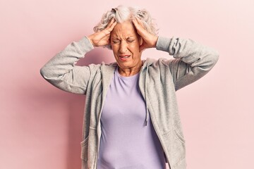 Senior grey-haired woman wearing casual sporty clothes suffering from headache desperate and stressed because pain and migraine. hands on head.