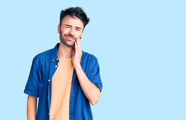 Fototapeta na wymiar Young hispanic man wearing casual clothes touching mouth with hand with painful expression because of toothache or dental illness on teeth. dentist