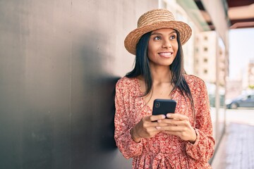 Young african american tourist woman on vacation smiling happy using smartphone at the city.