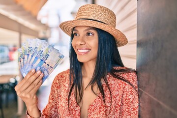 Young african american tourist woman on vacation holding south africa rand banknotes at the city.