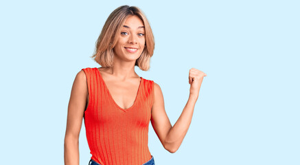 Naklejka na ściany i meble Beautiful caucasian woman wearing casual clothes smiling with happy face looking and pointing to the side with thumb up.