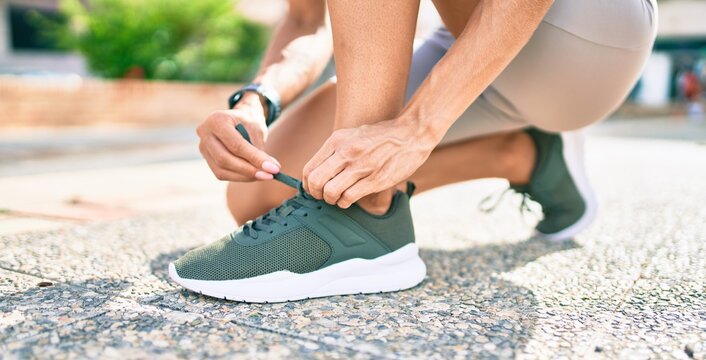 Close up of woman feet wearing training sneakers doing lace ready for running