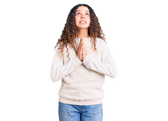 Beautiful kid girl with curly hair wearing casual clothes begging and praying with hands together with hope expression on face very emotional and worried. begging.