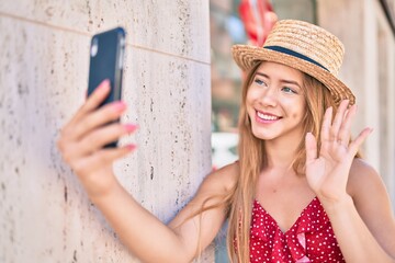 Young caucasian tourist girl smiling happy doing video call using smartphone at the city.