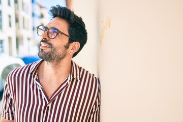 Young handsome hispanic man with beard smiling happy outdoors