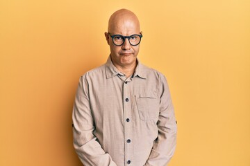 Middle age bald man wearing casual clothes and glasses skeptic and nervous, frowning upset because of problem. negative person.