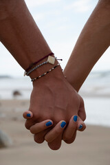 Young couple hold hands at the beach