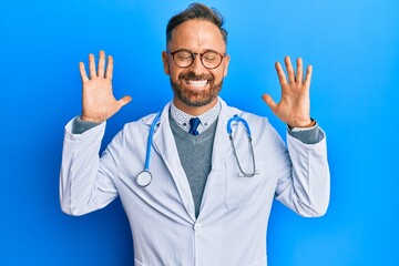 Handsome middle age man wearing doctor uniform and stethoscope celebrating mad and crazy for...