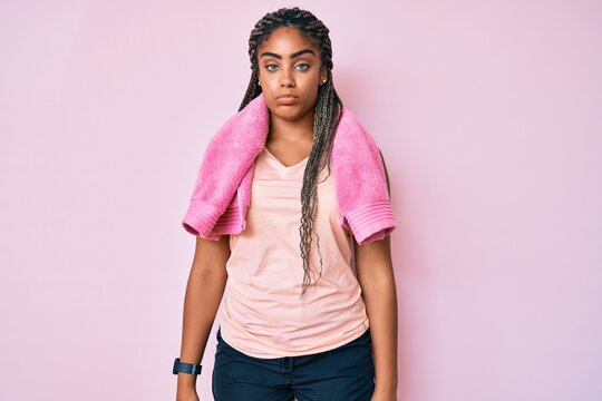 Young african american woman with braids wearing sportswear and towel depressed and worry for distress, crying angry and afraid. sad expression.