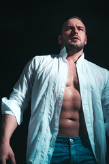 Muscular shirtless male model. Fashion portrait of young hot naked guy with open shirt revealing...