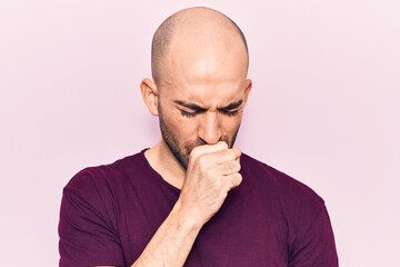 Young handsome bald man wearing casual t shirt feeling unwell and coughing as symptom for cold or bronchitis. health care concept.