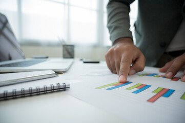 Close up hands businessman pointing paper work of financial graph chart data for analyse the...