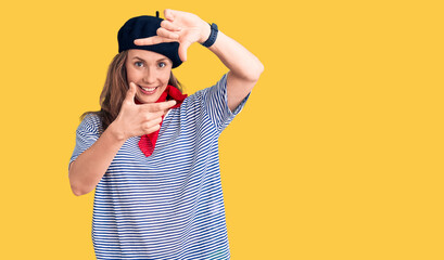 Young beautiful blonde woman wearing french beret and striped t-shirt smiling making frame with hands and fingers with happy face. creativity and photography concept.