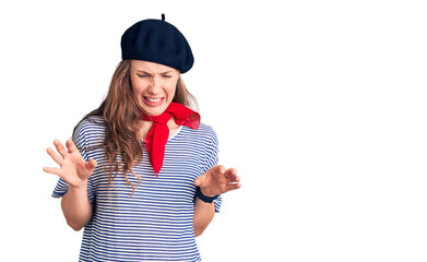 Young beautiful blonde woman wearing french beret and striped t-shirt disgusted expression,...