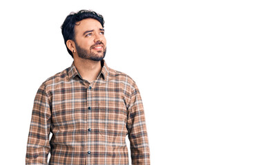 Young hispanic man wearing casual clothes smiling looking to the side and staring away thinking.