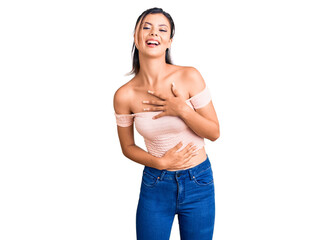 Obraz premium Young beautiful woman wearing casual clothes smiling and laughing hard out loud because funny crazy joke with hands on body.