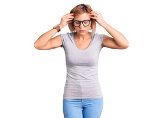 Young blonde woman wearing casual clothes with hand on head for pain in head because stress. suffering migraine.