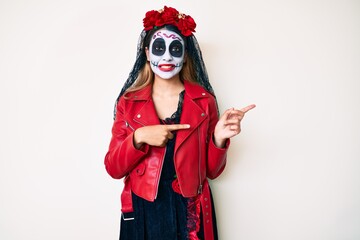 Woman wearing day of the dead costume over white pointing aside worried and nervous with both hands, concerned and surprised expression