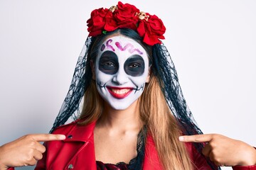 Woman wearing day of the dead costume over white looking confident with smile on face, pointing oneself with fingers proud and happy.