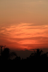 Fototapeta na wymiar Beautiful sunset with the silhouette of coconut trees