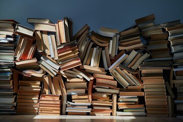 Pile of old books in dramatic dim light sunlight rays through window