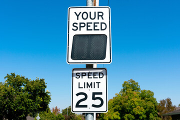 Your Speed, a radar speed sign that displays vehicle speed as motorists approach. 25 mph speed limit sign in residential neighborhood