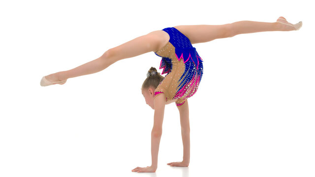 Beautiful girl gymnast performs a handstand.