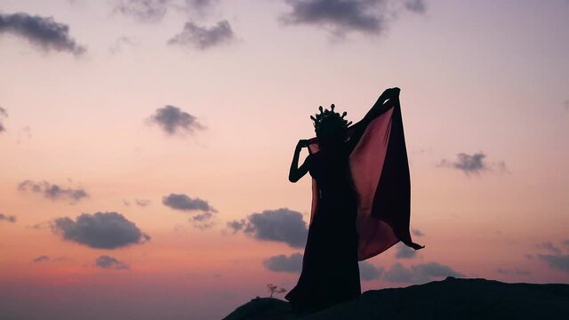 Silhouette of sexy, elegant and erotic arabian model performing belly dance on the beach during golden hour. Close up.