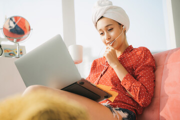 Work from home - Beautiful woman working instanly after taking shower infrontt of laptop computer, drinking coffe in the morning.