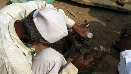 An old generation carpenter working with his instruments.