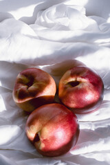 peaches on white cloth with American window light with a knife on sunny white background