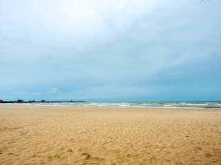 Seascape with sand beach under cloudy blue sky in Thailand