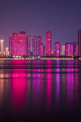 The city skyscrapers in colorful light and their reflection in rivers.