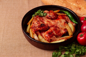 traditional georgian dish, tobacco chicken, with potatoes, on a wooden table, view from above