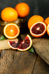 Sliced Sicilian Blood oranges fruits over old dark wooden background.