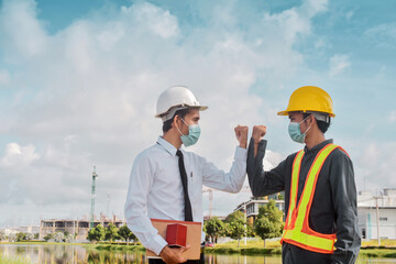 Engineers saluting each other by touching elbows,Two business people shake hand no touch outdoor on site construction