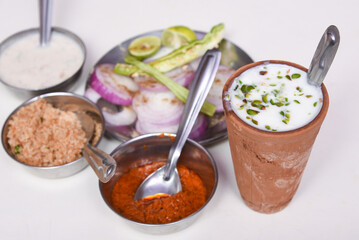 Sweet lassi a  traditional Indian savory cold drink and green salad Jaipur, India. blend of yogurt, cream, water, spices and sometimes fruits. Refreshing summer drink.