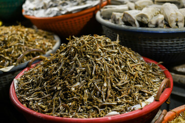 Night photo of baskets full of  heap of dried fish in a shop in the fish market in the city in Kochi, Kerala in India.