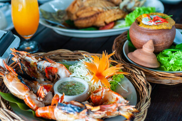 Grilled shrimp in wicker basket serve with spicky seafood sauce, Thai Steamed seafood curry Fresh shrimp roasted in Thailand.