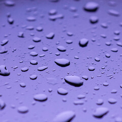 Water drop on mirror reflection with light made mor color blue green violet.