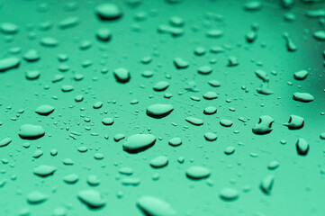 Water drop on mirror reflection with light made mor color blue green violet.