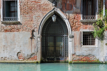 Venice building with old door for boats from Venice canal, Italy