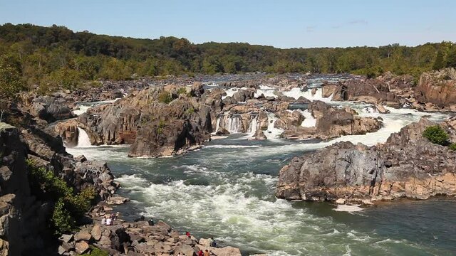 Close up view of the cascading water at great falls region of the potomac river. Image was taken from a scenic overlook at Great Falls park in virginia. Water sparkles as it moves fast through rocks.